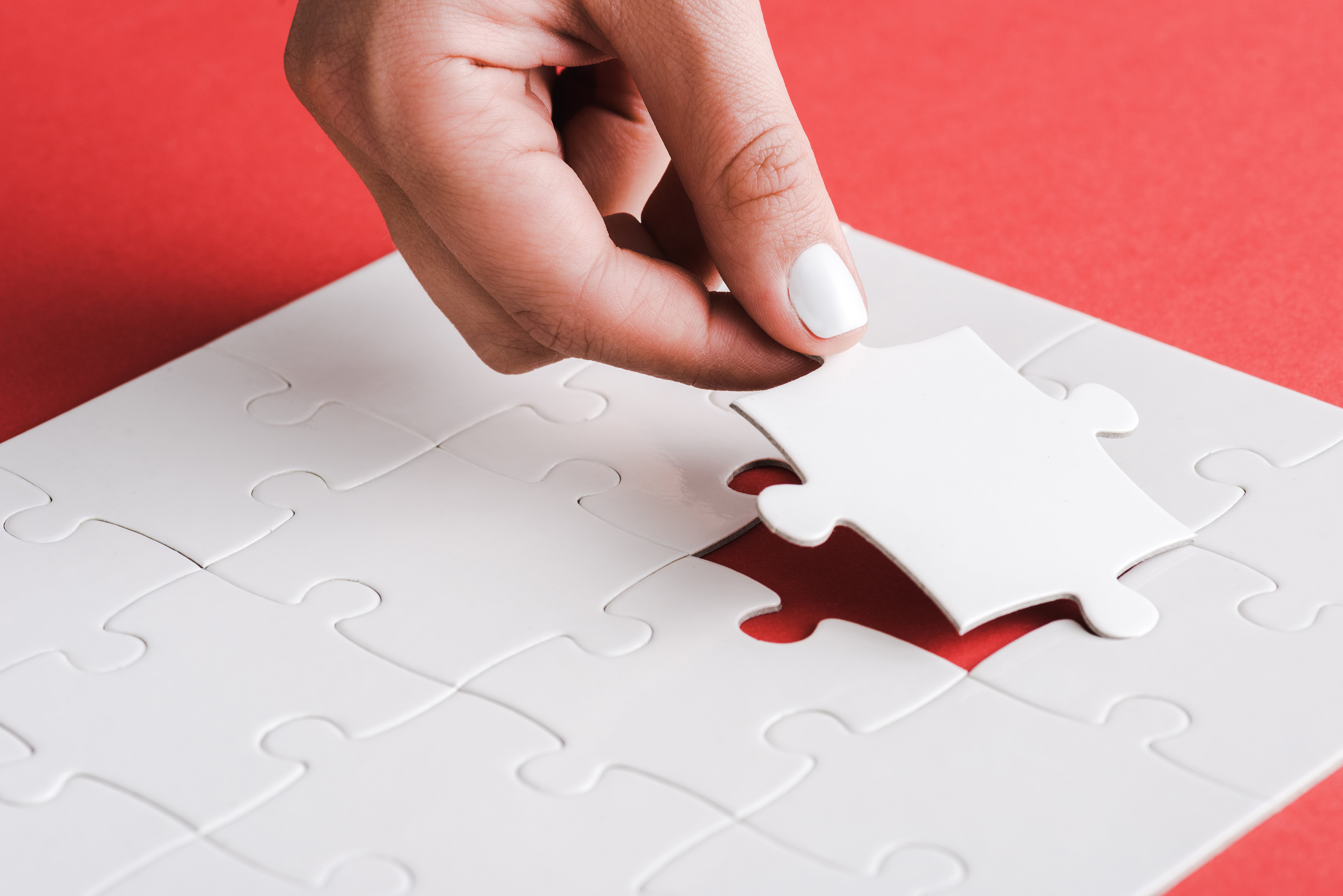 cropped-view-of-woman-holding-white-jigsaw